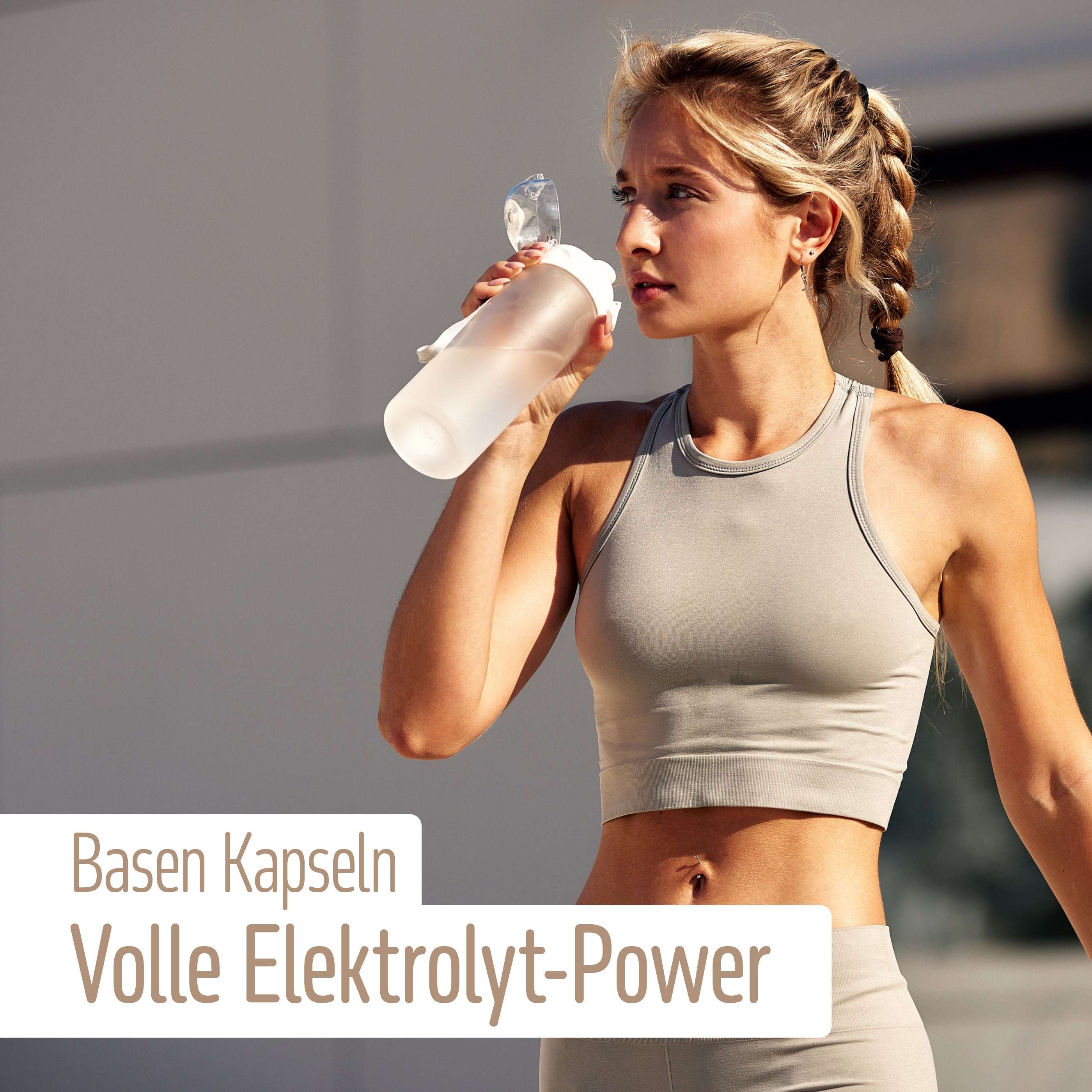 Eine Frau in Sportkleidung trinkt im Freien aus einer Wasserflasche, Sonnenlicht beleuchtet ihr geflochtenes Haar. Der Text lautet: fitne Basen Kapseln – volle Elektrolyt-Power mit basischen Mineralstoffen wie Calcium-Magnesiumcarbonat.