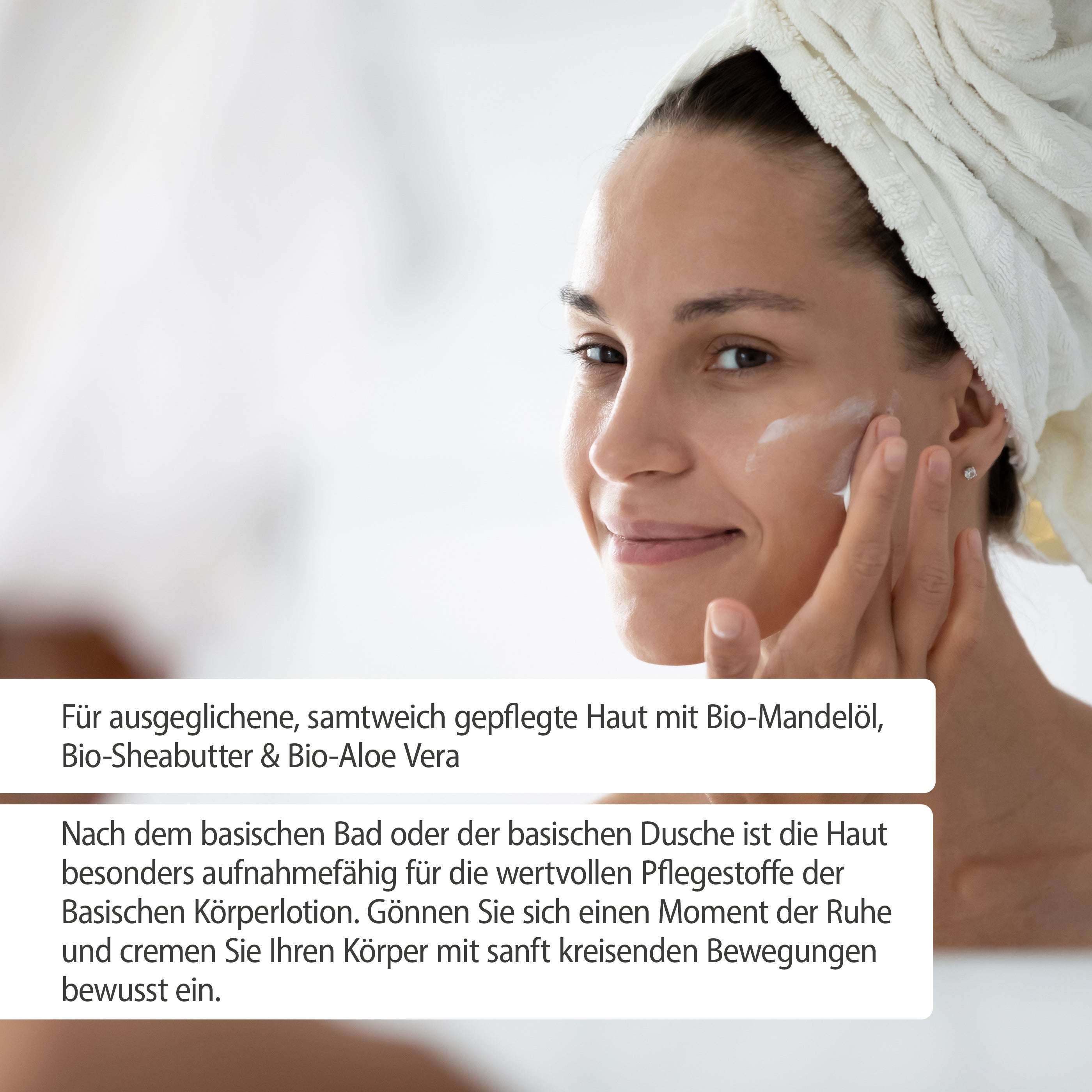 Eine Frau mit einem Handtuch um den Kopf lächelt, während sie fitne Basische Körperlotion aufträgt. Der deutsche Text hebt die Vorteile von Bio-Mandelöl und Bio-Sheabutter für weiche, gepflegte Haut hervor.