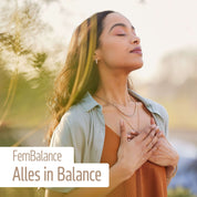 Eine ruhige Frau steht draußen mit geschlossenen Augen und den Händen auf der Brust. Der Text lautet: FemBalance von fitne – unterstützt Ihre hormonelle Balance mit wertvollen Mikronährstoffen. Sanfte Grüntöne und Sonnenlicht im Hintergrund.