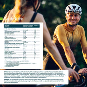Ein Mann in Radfahrerkleidung lächelt eine Frau im Freien unter sonnenbeschienenen Bäumen an. Auf der linken Seite weist ein Ernährungstisch von FITNE Health Care Nährstoffkomplex Knorpel & Knochen auf die Unterstützung gesunder Gelenke hin.