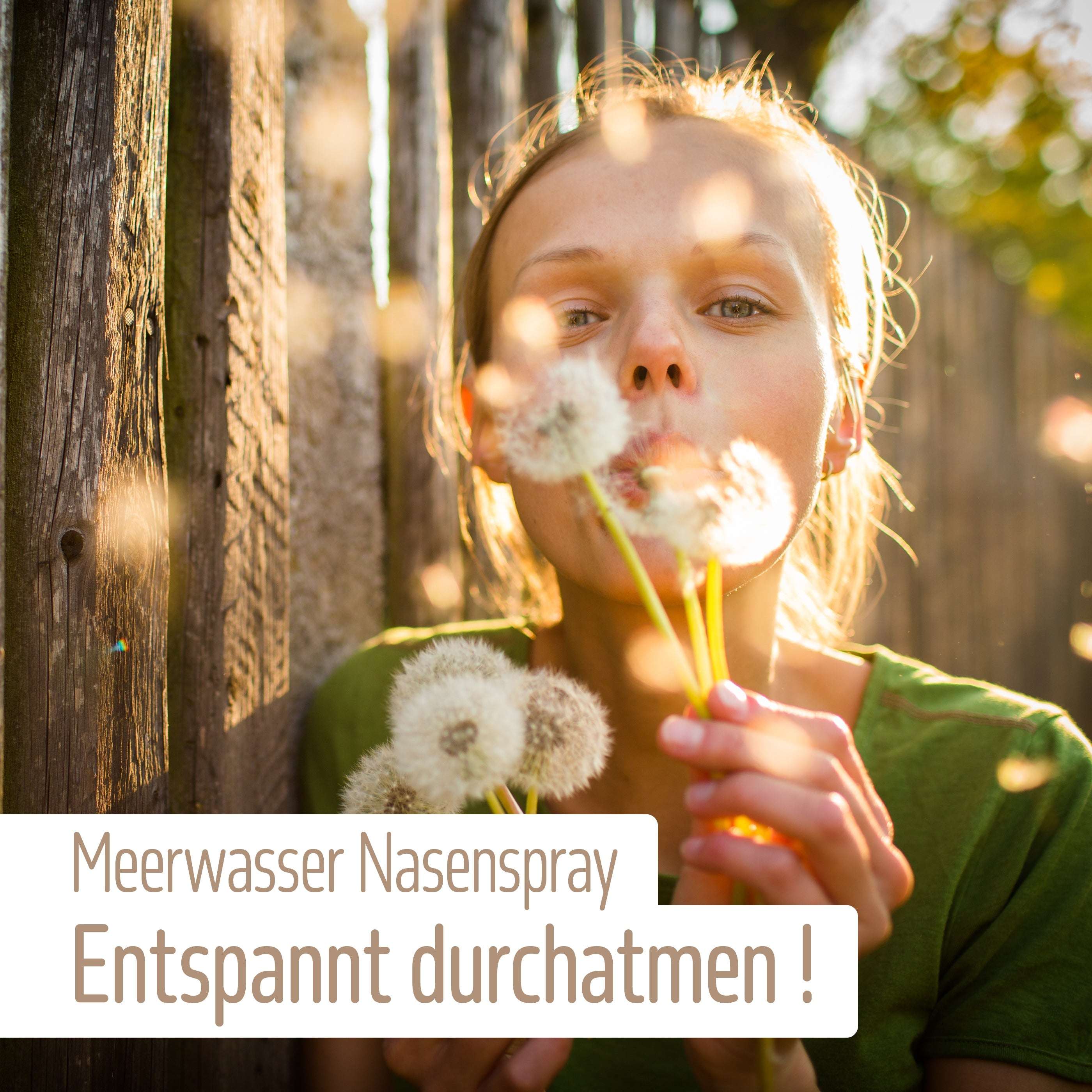 Eine Frau in einem grünen Hemd bläst auf Löwenzahn, während das Sonnenlicht durch die Bäume dringt. Deutscher Text: fitne Meerwasser Nasenspray – mit natürlicher Meerwasserlösung für die Befeuchtung der Nasenschleimhaut und entspanntes Durchatmen!.