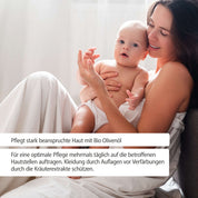 Eine lächelnde Frau in einem weißen Bademantel hält ein in ein Handtuch gewickeltes Baby. Der deutsche Text darunter gibt Pflegetipps für gestresste Haut mit FITNE Health Care Bio Ringelblumen Salbe und empfiehlt eine regelmäßige Anwendung zum Schutz vor Verfärbungen.