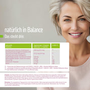 Eine lächelnde Frau mit kurzen blonden Haaren sitzt auf einem Sofa. Die Verpackung der fitne Meno Balance Kapseln präsentiert sich in klarem Grün-Weiß-Design und enthält auf Deutsch Angaben zu Inhaltsstoffen, Tagesdosis und Nährwerten.